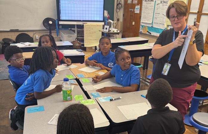  Math/ Science teacher teaching to a small group of students additional Math skill on Lunch hour.